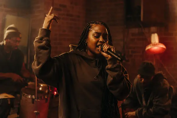 A rapper performing her bars into a microphone
